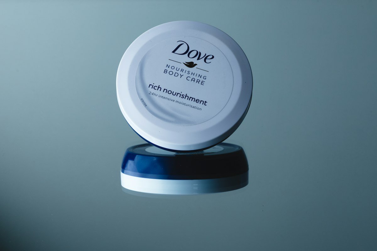 Jar of rich nourishing body cream on a reflective surface